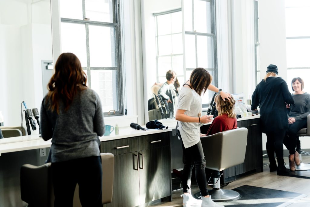 Mehrere Friseurinnen und Kundinnen in einem Salon.