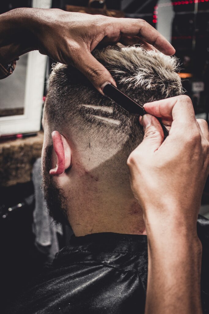Einem Mann wird in einem Barbershop eine Frisur verpasst.