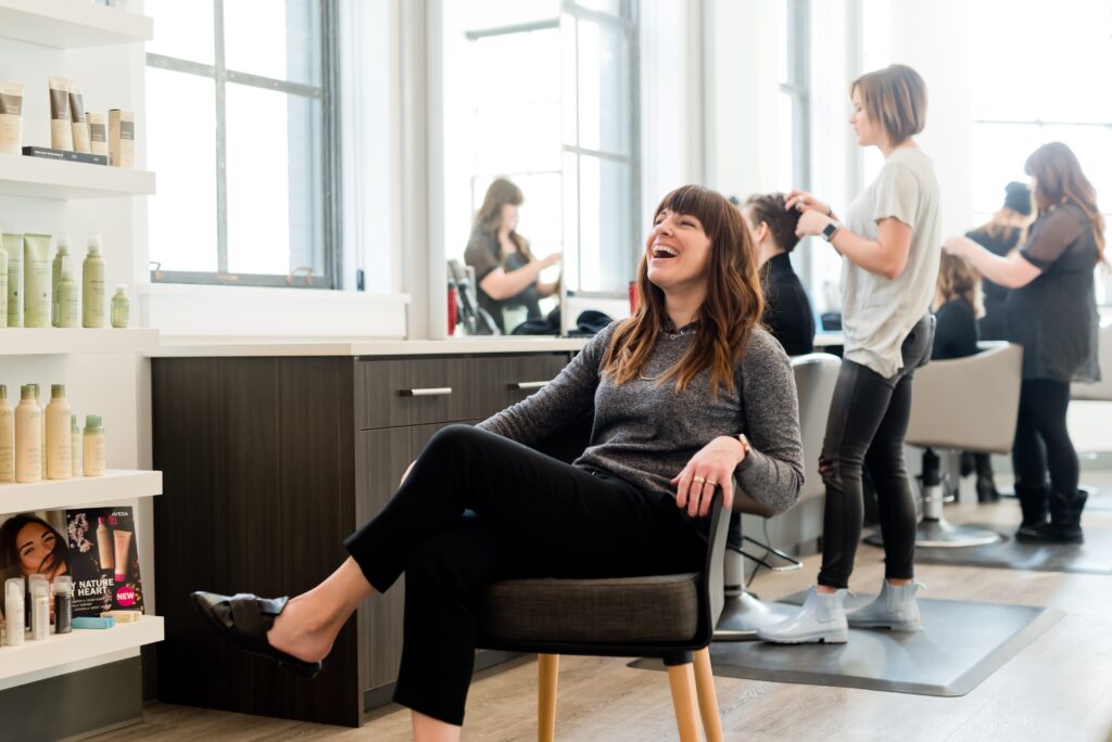 Friseurin lacht im Salon.