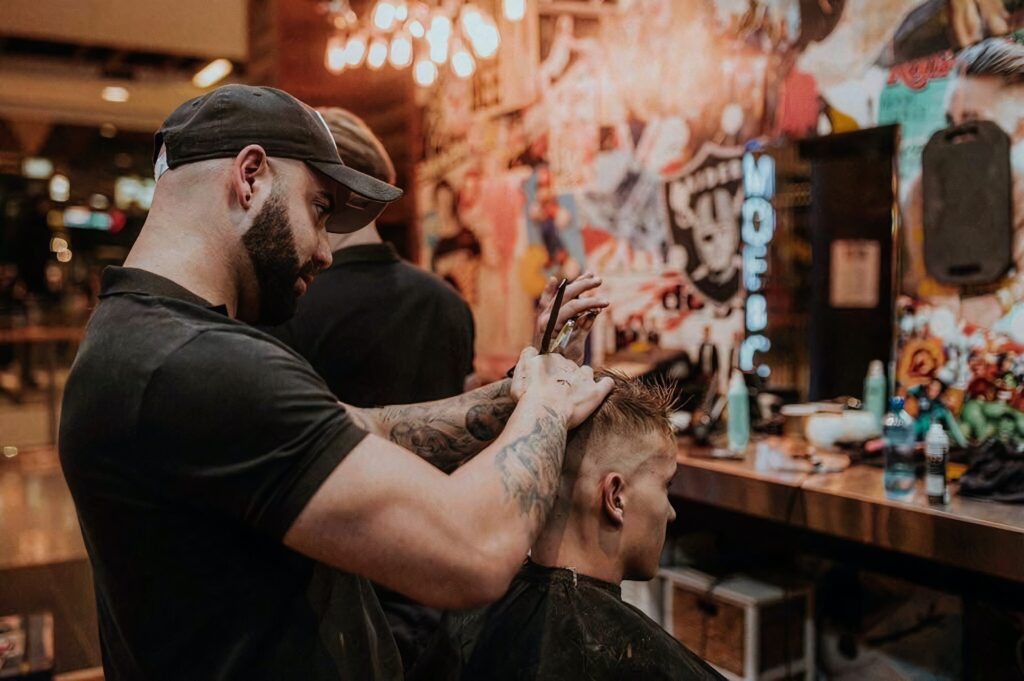 Einem Mann werden in einem Barbershop die Haare geschnitten.