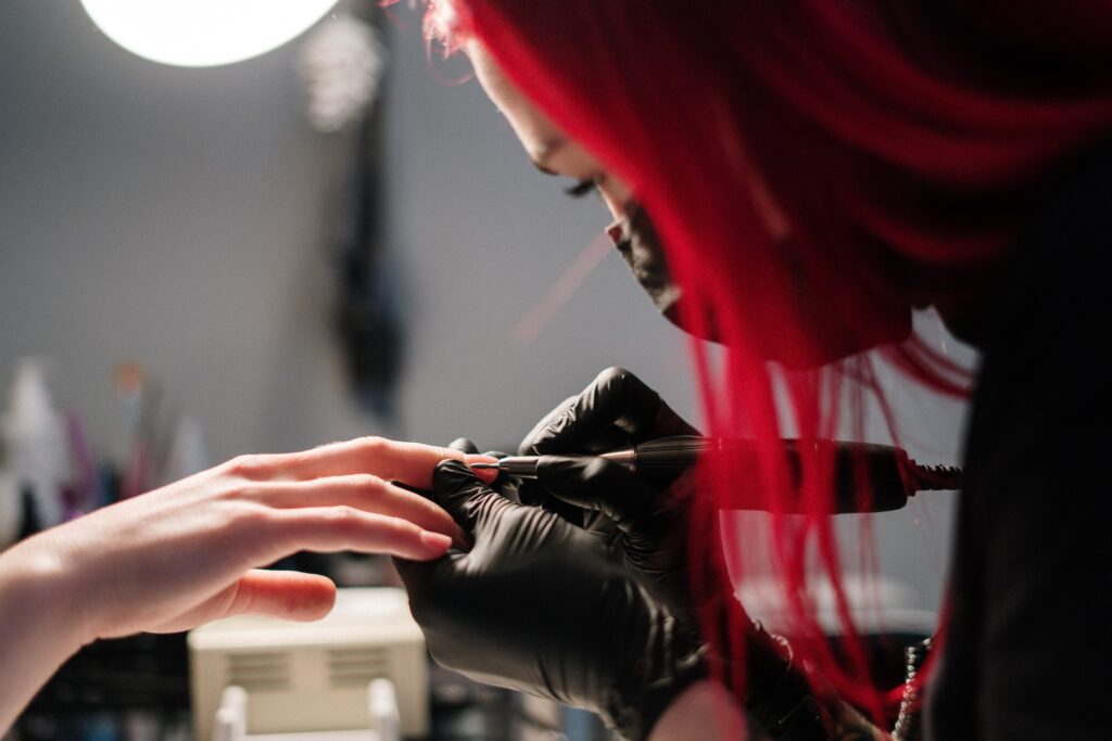 Eine Nageldesignerin in einem Salon bei der Arbeit.