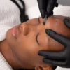 Nahaufnahme einer Kosmetikerin, die bei einer Kundin im Salon ein Dermaplaning durchführt